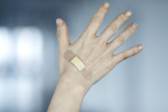 Close up of woman with band-aid on hand
