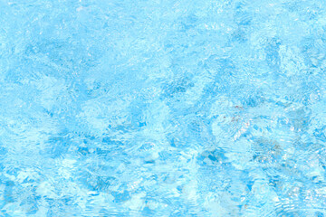 Blue waving, sparkling water in the pool. Abstract background.