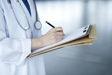 Close up of doctor taking notes. Health care and medical concept.