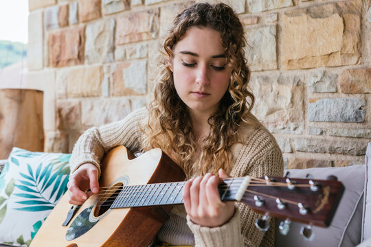 Young woman playing guitar outdoors