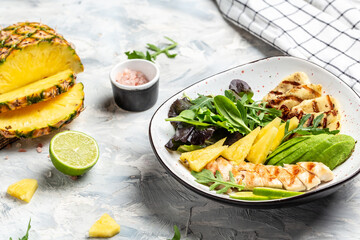 Tasty summer appetizing summer salad with grilled chicken, halloumi, avocado, green rocket salad, lime, sesame and seeds. Food recipe background. Close up