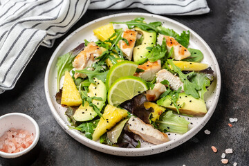 grilled chicken breast salad with pineapple, avocado, green rocket salad and lime. Healthy juicy food. Food recipe background. Close up