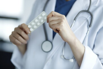 Close up of doctor holding pack of medicine