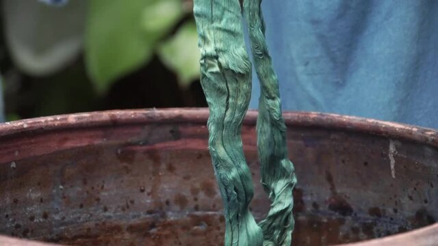Handmade traditional technique of fabric dyeing in natural indigo colour in Thailand