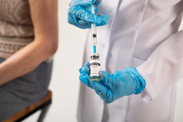 Doctor prepares a syringe with coronavirus vaccine for a patient.