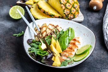 Tasty summer appetizing summer salad with grilled chicken, halloumi, avocado, green rocket salad, lime, sesame and seeds. Food recipe background. Close up