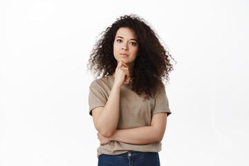Portrait of complicated woman making decision, thinking and looking serious at camera, ponder choice, standing thoughtful against white background - obrazy, fototapety, plakaty