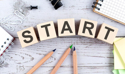 START text on wooden block with office tools on the wooden background