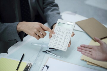 Business people using calculator in meeting