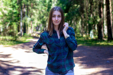 Young beautiful smiling girl walking along the forest path