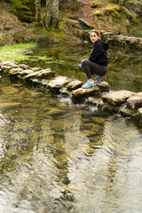 Obraz premium MOUNTAIN PATH ON A STONE PATH THAT CROSSES A RIVER.