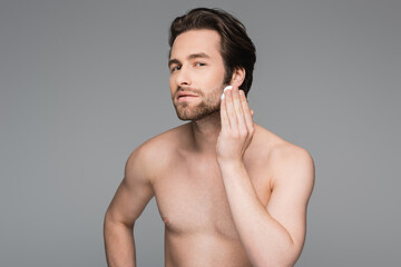 Fototapeta premium bearded man applying white shaving foam on face isolated on grey.
