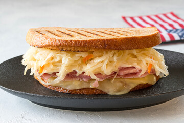 Reuben sandwich is a classic American hot sandwich with sliced beef, Swiss cheese, sauerkraut and...