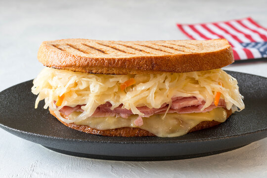 Reuben sandwich is a classic American hot sandwich with sliced beef, Swiss cheese, sauerkraut and sauce.