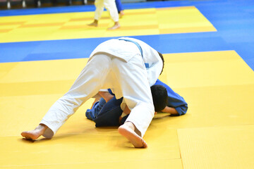 Two Boys judoka in kimono compete on the tatami 