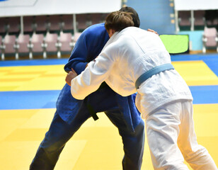 Two Boys judoka in kimono compete on the tatami 