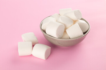 Marshmallow in bowl on pastel pink background.