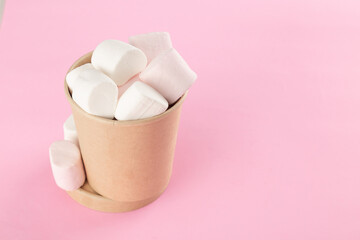 Marshmallow in bucket on pastel pink background.