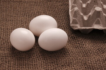 chicken eggs on the table. Farm products, natural eggs in jute background.