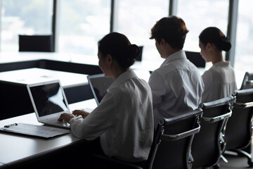 Coworkers having meeting with laptop in conference room