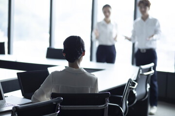 Businesswoman listening to presentation from coworker during meeting