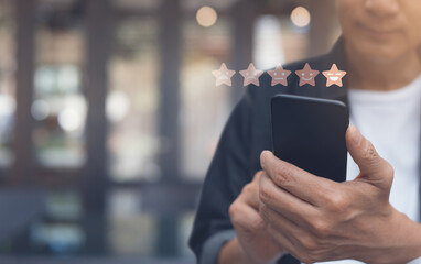  Man hand using mobile phone with icon five star symbol to increase rating of company, customer...