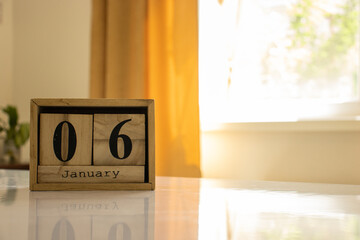 Wooden blocks of the calendar represents the date 6 and the month of January on the background of a...