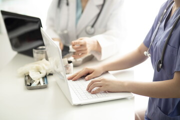 Doctors using laptop in meeting