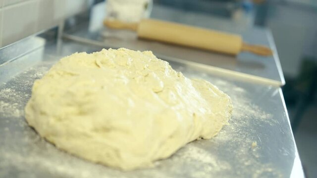 The chef professionally rolls out the dough