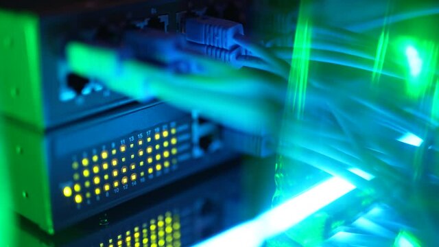 Close-up view of modern internet network switch with plugged ethernet cables. Blinking lights on internet server. Concept of data center. Cloud computing and telecommunications