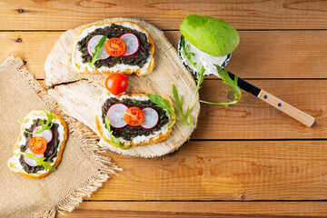 Healthy sandwiches with avocado, cream cheese and radish. Healthy toast with cream cheese, avocado,...