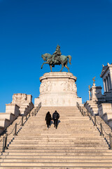 Obraz premium Rome Piazza Venezia Altar of the Fatherland, equestrian monument of Vittorio Emanuele II, Italy. Detail of the staircase with two tourists. Italian National Monument on the Capitoline Hill. Europe.