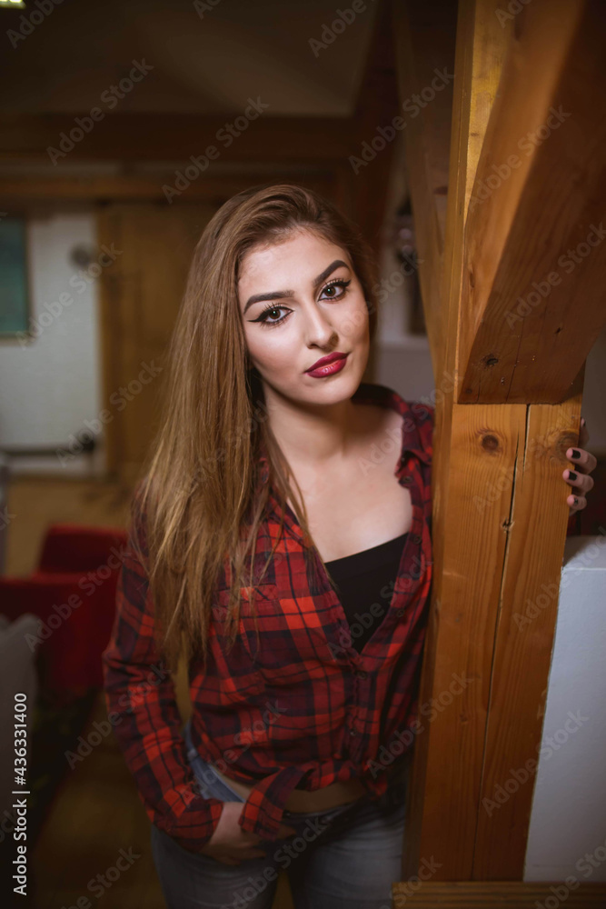 Wall mural Vertical shot of a white Caucasian woman posing for a picture on a blurred background