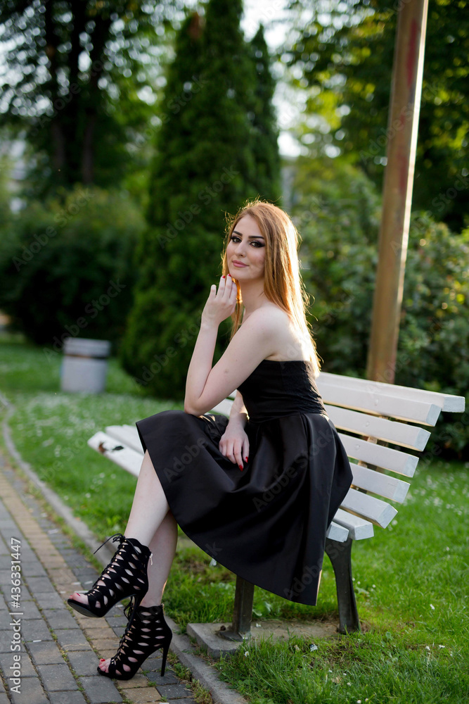 Sticker vertical shot of a white caucasian woman wearing a black classic dress and posing for a picture