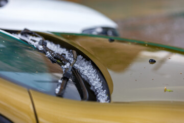 small hail ice balls on yellow car hood after heavy summer storm - obrazy, fototapety, plakaty