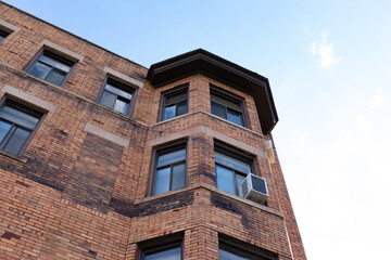 Fototapeta na wymiar Very old brick apartment building with new replacement windows, horizontal aspect