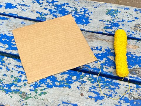 square-shaped cardboard and scissors on a blue background, kids craft.