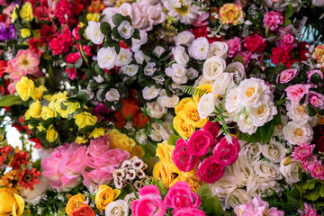 Many colorful artificial fake flowers background blooming beautiful.
