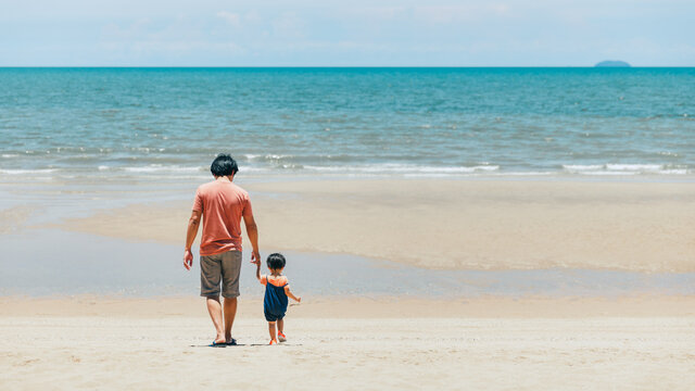 Asian family father and child relax and travel on summer beach Thailand