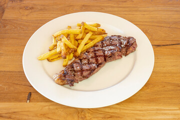 Grilled beef tenderloin garnished with coarse salt and a side of French fries
