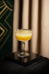 cocktail in a beautiful glass stands on a marble pedestal 