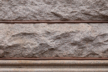 Background of rusticated granite blocks divided by beaded mortar, architectural details, horizontal...