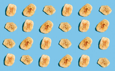 Banana chips on a blue background. Banana pattern. Healthy diet.