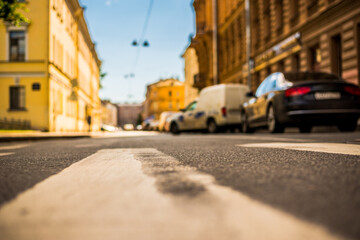 Clear day in the big city, quiet street with parked cars. View from the pedestrian crossing