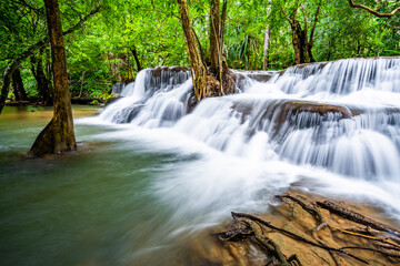 Obraz premium Waterfall and blue emerald water color in Huay Mae Khamin national park. Huay Mae Khamin, Beautiful nature rock waterfall steps in tropical rainforest at Kanchanaburi province, Thailand