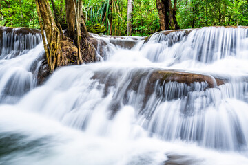 Fototapeta na wymiar Waterfall and blue emerald water color in Huay Mae Khamin national park. Huay Mae Khamin, Beautiful nature rock waterfall steps in tropical rainforest at Kanchanaburi province, Thailand