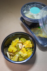 Fruit salad with pineapple and banana in a container. Food delivery