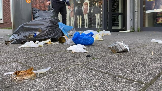 Trash on the city sidewalk near metal trash bin in pandemic lockdown. Environmental protections 2.