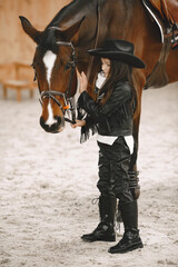 Little girl is riding a horse in a rancho