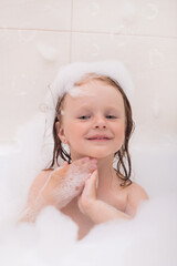 baby bathes playing in the bathtub with foam